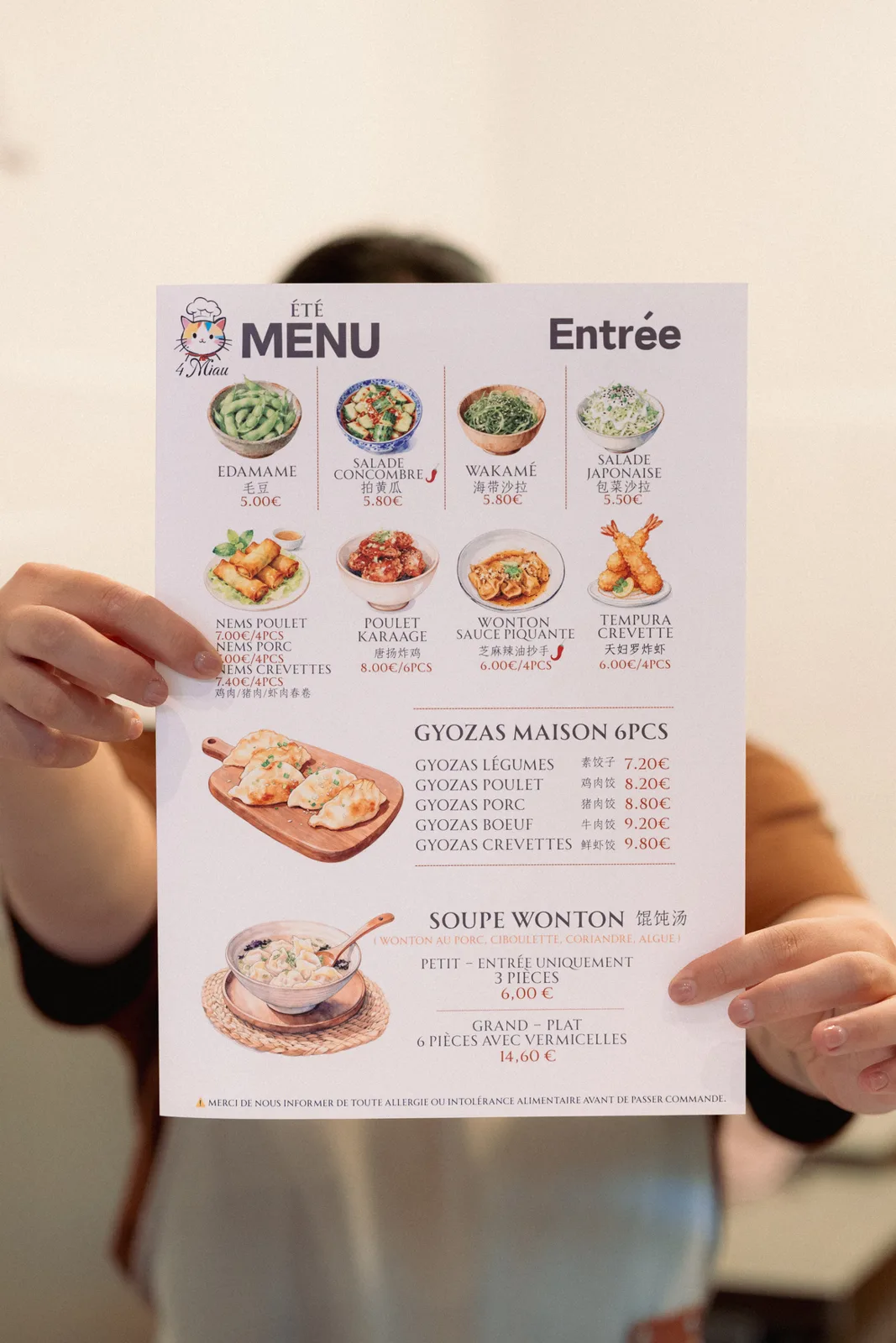 La carte d'été du 4 Miau, tenue en main dans la salle